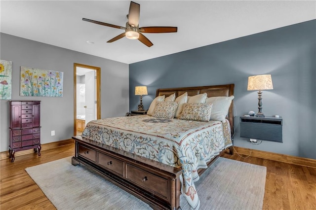 bedroom featuring baseboards, ceiling fan, wood finished floors, and a wall unit AC
