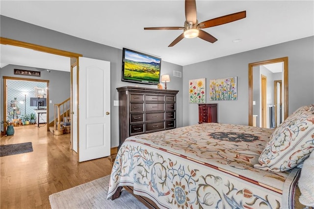 bedroom featuring a ceiling fan, visible vents, and wood finished floors