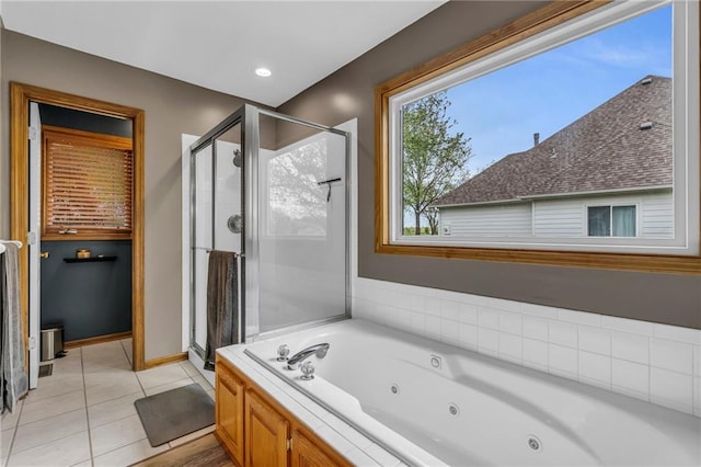 full bathroom featuring a tub with jets, tile patterned flooring, baseboards, and a stall shower
