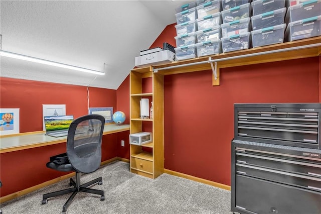 carpeted home office with baseboards and vaulted ceiling