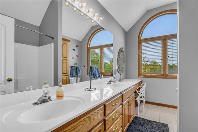 bathroom featuring double vanity, tile patterned floors, a sink, and lofted ceiling