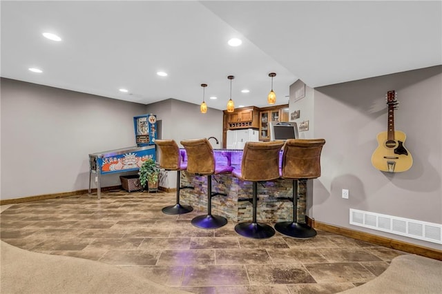 bar featuring visible vents, freestanding refrigerator, baseboards, recessed lighting, and bar
