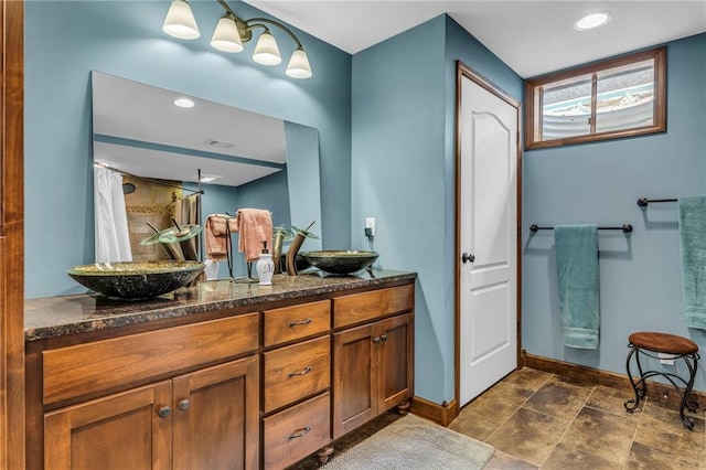 full bath with double vanity, baseboards, and curtained shower