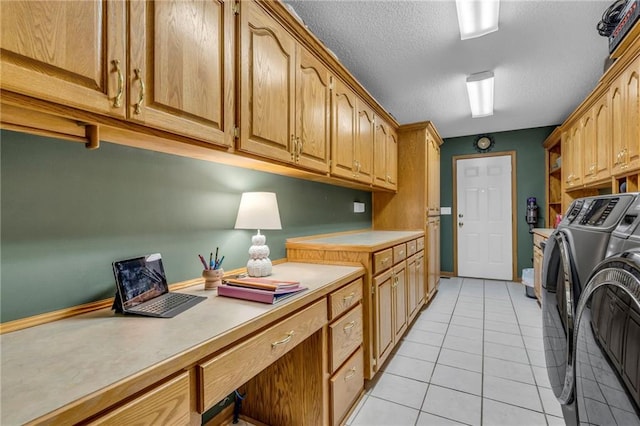 washroom with light tile patterned floors, a textured ceiling, cabinet space, and washer and dryer