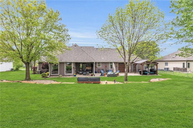 rear view of property with fence, a yard, a patio area, and roof with shingles