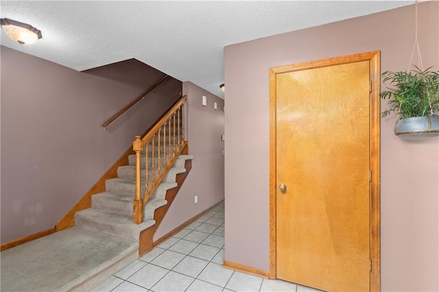 808 S Mohican Dr, Independence, MO 64056 - staircase with tile patterned floors, baseboards, and a textured ceiling