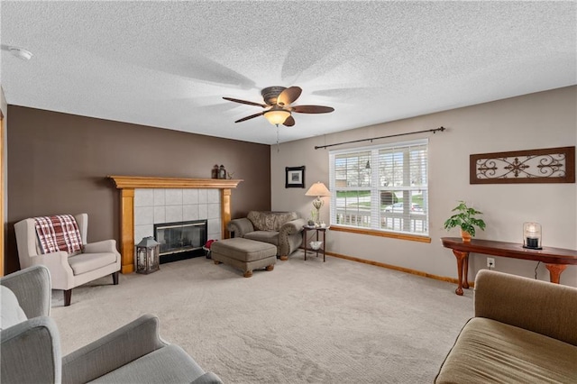 808 S Mohican Dr, Independence, MO 64056 - living area with ceiling fan, a textured ceiling, carpet floors, a tiled fireplace, and baseboards