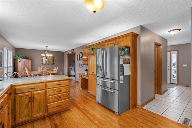808 S Mohican Dr, Independence, MO 64056 - kitchen with stainless steel fridge with ice dispenser, brown cabinetry, and plenty of natural light