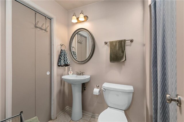 808 S Mohican Dr, Independence, MO 64056 - bathroom featuring toilet, a sink, baseboards, and tile patterned flooring