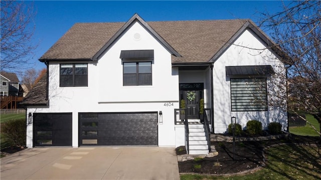 view of front of property with an attached garage, a shingled roof, driveway, and stucco siding