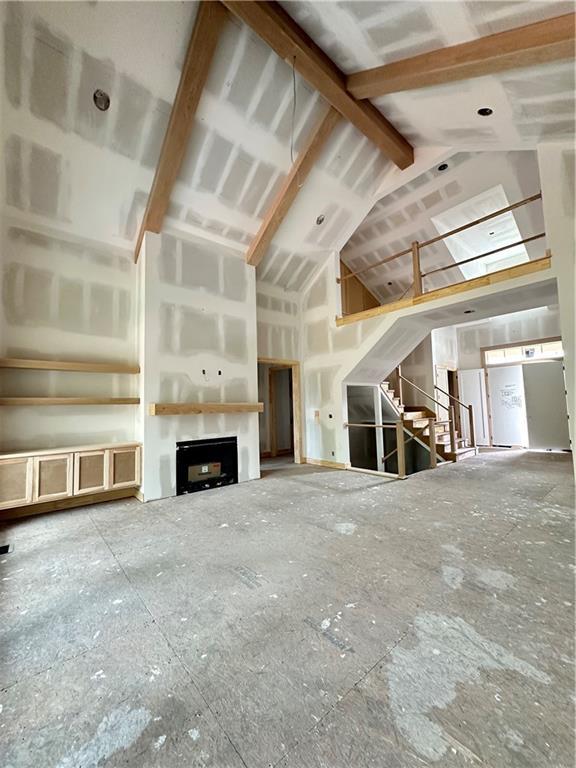 17216 Goddard St, Overland Park, KS 66221 - unfurnished living room featuring stairs, vaulted ceiling, and a fireplace
