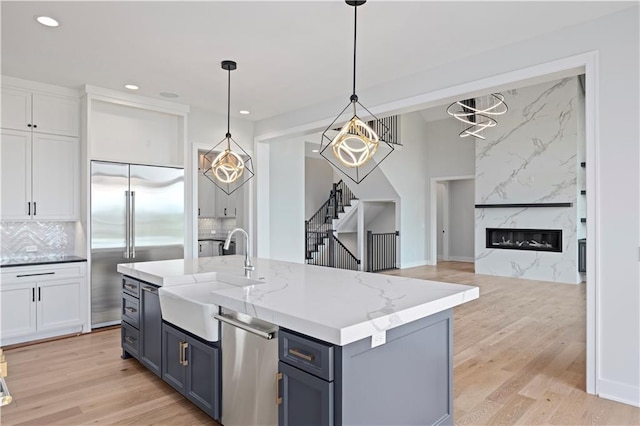 17216 Goddard St, Overland Park, KS 66221 - kitchen featuring a sink, light wood-type flooring, appliances with stainless steel finishes, recessed lighting, and white cabinetry
