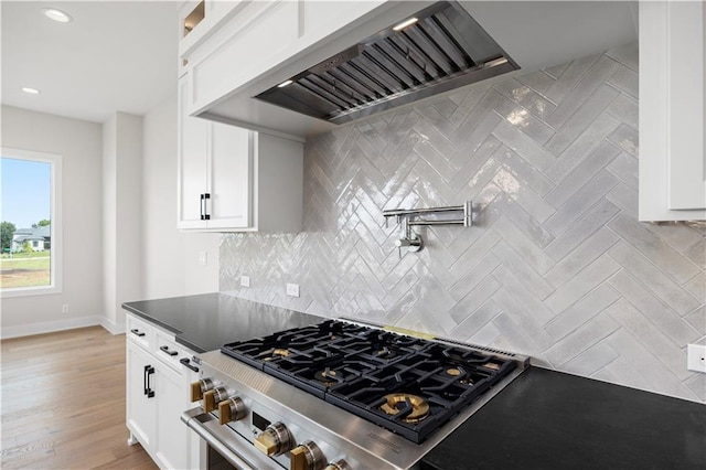 17216 Goddard St, Overland Park, KS 66221 - kitchen with custom exhaust hood, stainless steel stove, dark countertops, white cabinetry, and decorative backsplash