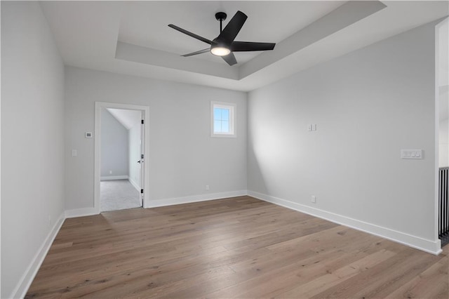 17216 Goddard St, Overland Park, KS 66221 - empty room featuring light wood-style floors, ceiling fan, baseboards, and a raised ceiling