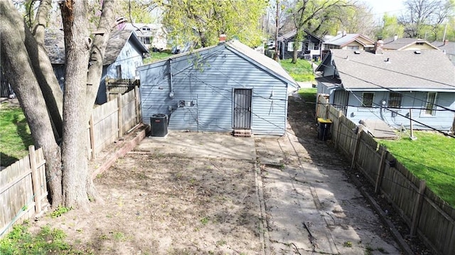 2907 E 61st St, Kansas City, MO 64130 - rear view of house with central AC unit, a fenced backyard, and a residential view