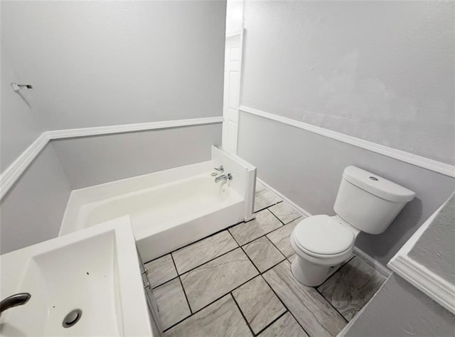 2907 E 61st St, Kansas City, MO 64130 - bathroom featuring toilet, a bath, and tile patterned flooring