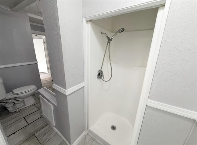 2907 E 61st St, Kansas City, MO 64130 - bathroom featuring a stall shower, toilet, and baseboards