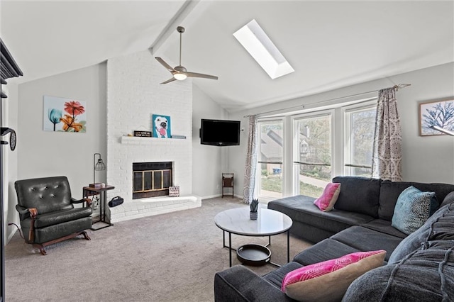 living room featuring ceiling fan, carpet flooring, lofted ceiling with skylight, and a brick fireplace