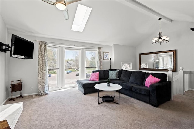 carpeted living area featuring lofted ceiling with skylight and a chandelier