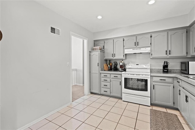kitchen featuring white range with electric stovetop, gray cabinets, stainless steel microwave, under cabinet range hood, and visible vents