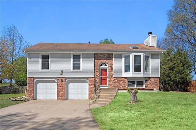 split foyer home featuring a garage, a front lawn, fence, a chimney, and concrete driveway