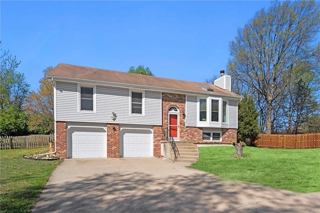 bi-level home featuring fence, an attached garage, a front yard, a chimney, and driveway