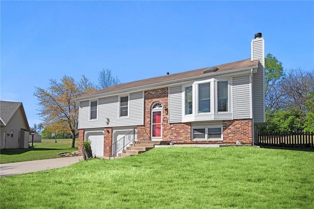 split foyer home with fence, brick siding, a garage, a chimney, and driveway