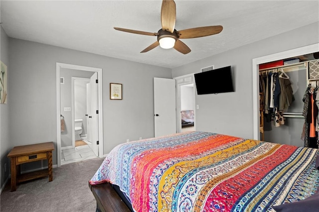 bedroom featuring ceiling fan, baseboards, a closet, carpet, and ensuite bath