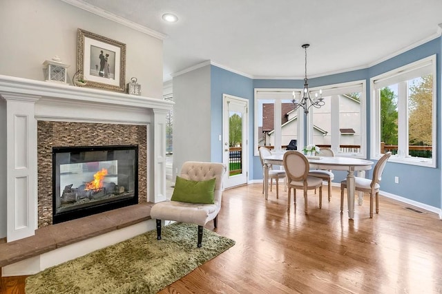 9011 NE 91st Ter, Kansas City, MO 64157 - dining room with baseboards, a chandelier, a premium fireplace, ornamental molding, and wood finished floors