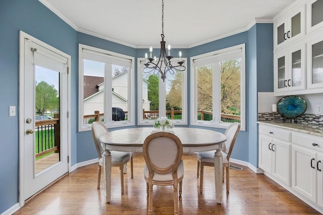 9011 NE 91st Ter, Kansas City, MO 64157 - dining area with a chandelier, wood finished floors, ornamental molding, and baseboards