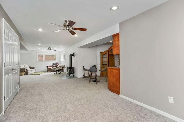 9011 NE 91st Ter, Kansas City, MO 64157 - living area with a ceiling fan, light colored carpet, recessed lighting, baseboards, and a wood stove
