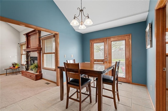 16011 Cedar St, Basehor, KS 66007 - dining room featuring healthy amount of natural light, a chandelier, a fireplace with raised hearth, french doors, and high vaulted ceiling