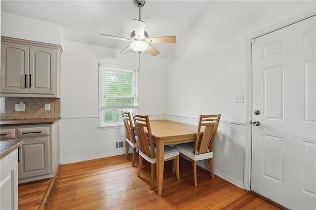dining room featuring ceiling fan, visible vents, baseboards, and light wood finished floors