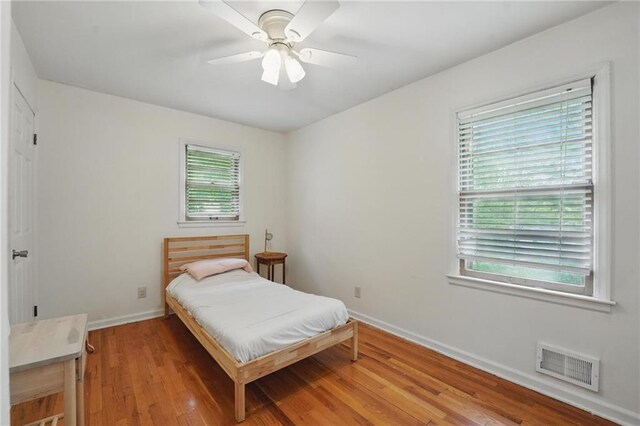 bedroom with visible vents, baseboards, ceiling fan, and light wood-type flooring