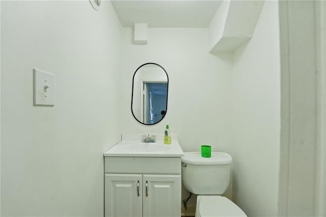 half bathroom with toilet and vanity