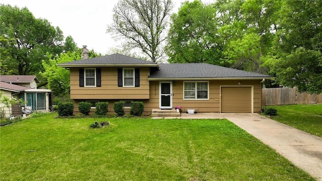 split level home featuring driveway, a chimney, a front yard, a garage, and fence