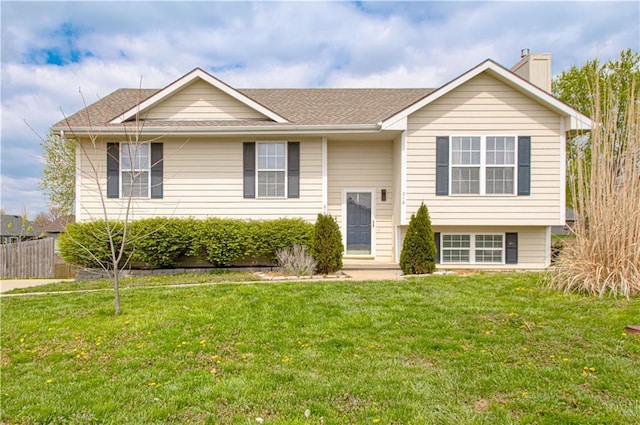 310 E 22nd St, Kearney, MO 64060 - bi-level home featuring fence, a front lawn, a chimney, and roof with shingles