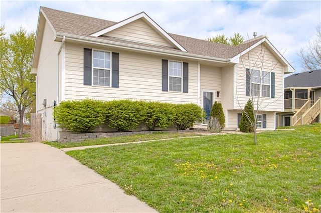 310 E 22nd St, Kearney, MO 64060 - bi-level home with stairway, roof with shingles, and a front yard