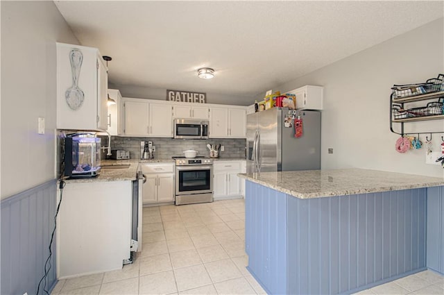 310 E 22nd St, Kearney, MO 64060 - kitchen featuring white cabinets, tasteful backsplash, light stone counters, and stainless steel appliances