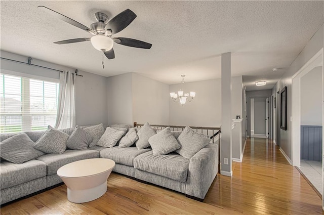 310 E 22nd St, Kearney, MO 64060 - living area featuring ceiling fan with notable chandelier, baseboards, a textured ceiling, and light wood-type flooring