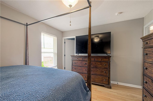 310 E 22nd St, Kearney, MO 64060 - bedroom with baseboards, a textured ceiling, and light wood-style floors