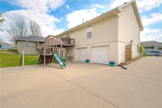 310 E 22nd St, Kearney, MO 64060 - rear view of house with a garage and a playground
