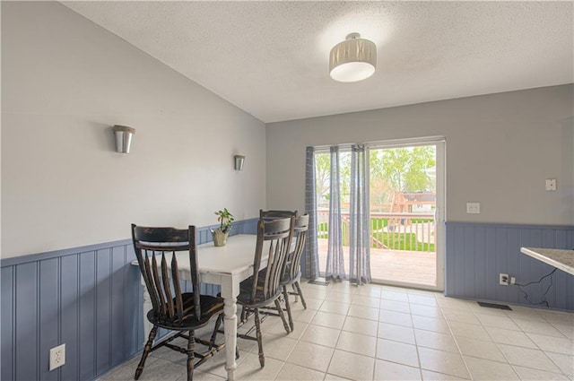 310 E 22nd St, Kearney, MO 64060 - dining room with wainscoting, visible vents, a textured ceiling, and light tile patterned floors