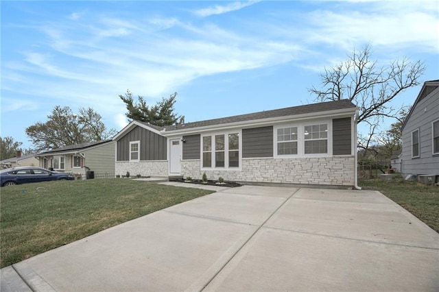 ranch-style house with board and batten siding, driveway, a front yard, and stone siding