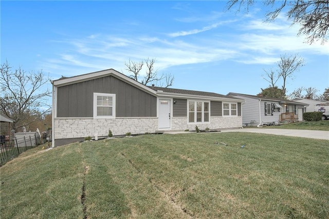ranch-style home featuring a front yard, stone siding, and fence