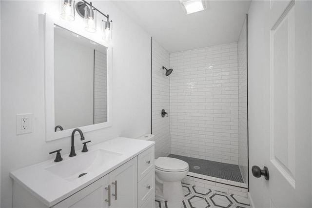 bathroom with toilet, vanity, and a stall shower