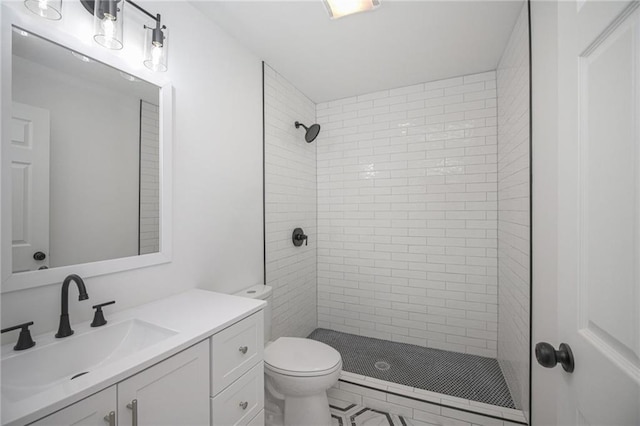 bathroom featuring toilet, vanity, and a stall shower