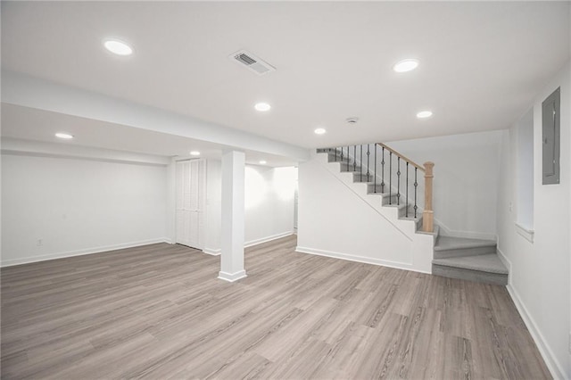 finished below grade area with stairs, visible vents, baseboards, and wood finished floors
