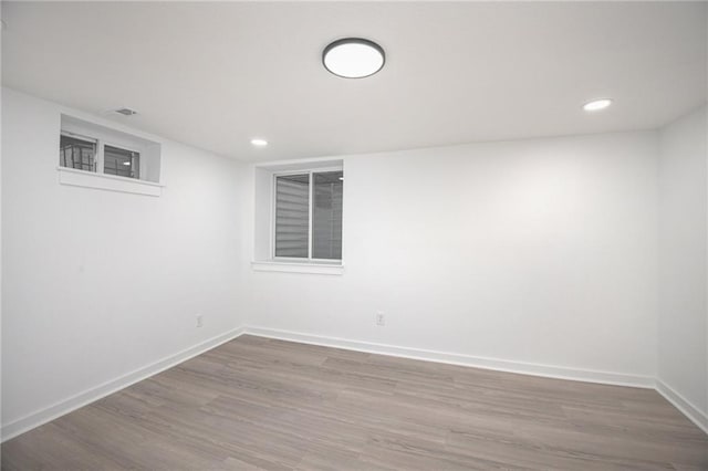 unfurnished room featuring baseboards, recessed lighting, and wood finished floors
