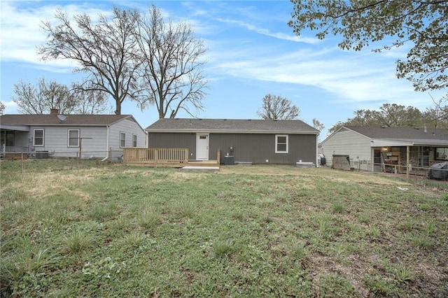 back of house featuring a yard, fence, and a deck